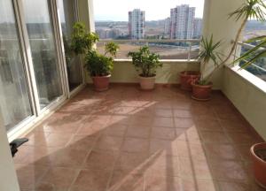 an empty balcony with potted plants and windows at Квартира in Antalya