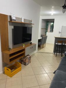 a living room with a flat screen tv on a wall at Ap 202 Hospedagem in Rio das Ostras