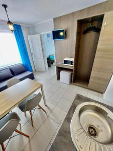 ein Wohnzimmer mit einem Tisch und Stühlen sowie eine Küche in der Unterkunft Villa Baltic Karwia in Karwia