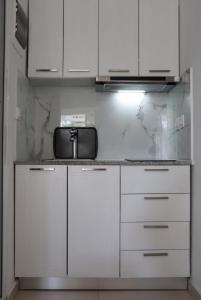 uma cozinha com armários brancos e uma bancada em Fiosal Apartments 2 em Skiathos