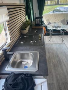 una cocina con fregadero en una cabaña en Domek holenderski -noclegi, en Mielno