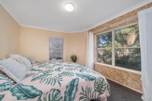 a bedroom with a bed and a large window at Ocean Shores 2 in South West Rocks
