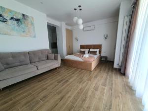 - un salon avec un canapé et un lit dans l'établissement MIANELLY Apartments Mamaia Nord, à Mamaia Nord – Năvodari