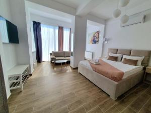 a bedroom with a bed and a couch and a table at MIANELLY Apartments Mamaia Nord in Mamaia Nord