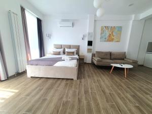 - une chambre avec un lit et un canapé dans l'établissement MIANELLY Apartments Mamaia Nord, à Mamaia Nord – Năvodari
