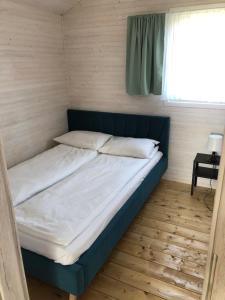 a bed in a small room with a window at Baltic Holidays in Gąski