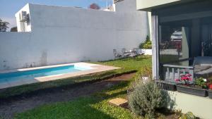 a swimming pool in a yard next to a house at Home J y M in Concordia