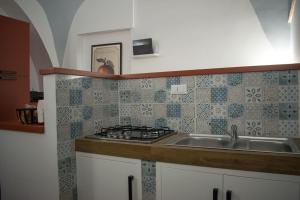 una cucina con lavandino e piano cottura di San Martino [Old Town Apartment - Itri] a Itri