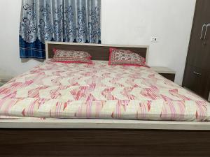 ein Bett mit zwei Kissen darauf in einem Schlafzimmer in der Unterkunft Parmarth Lok in Deoghar