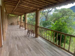 un porche de una casa con terraza de madera en El jardín de la salud hotel, en Fortín de las Flores