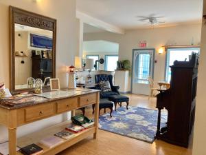 a living room with a desk and a mirror at Castle Rock Country Inn in Ingonish Beach