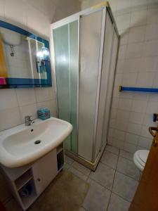 uma casa de banho com um lavatório e um chuveiro em La Casa di Adele em Porto SantʼElpidio