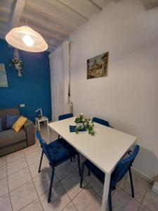 uma sala de estar com uma mesa branca e cadeiras azuis em La Casa di Adele em Porto SantʼElpidio