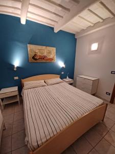 um quarto com uma cama grande numa parede azul em La Casa di Adele em Porto SantʼElpidio