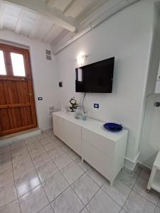 um quarto branco com uma televisão de ecrã plano na parede em La Casa di Adele em Porto SantʼElpidio