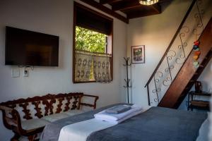 a bedroom with a bed and a television and stairs at Villa Santo Antonio - Mucugê in Mucugê