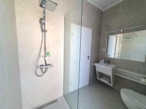 uma casa de banho com um chuveiro, um WC e um lavatório. em MIANELLY Apartments Mamaia Nord em Mamaia Nord – Năvodari