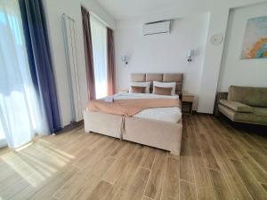 um quarto com uma cama grande e um sofá em MIANELLY Apartments Mamaia Nord em Mamaia Nord – Năvodari