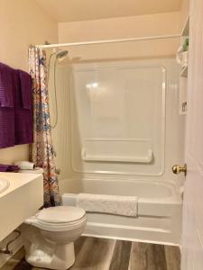 ein weißes Bad mit einem WC und einer Dusche in der Unterkunft Castle Rock Country Inn in Ingonish Beach