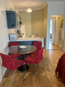 uma cozinha com uma mesa e algumas cadeiras vermelhas em 27 Cill Ard Bohermore galway em Galway