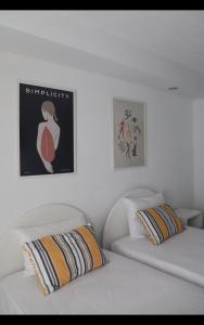 - une chambre avec 2 lits et une photo sur le mur dans l'établissement Fiosal Apartments 2, à Skiathos Chora