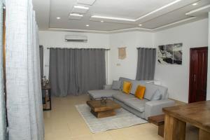 ein Wohnzimmer mit einem Sofa und einem Tisch in der Unterkunft Résidences Inaya in Cotonou