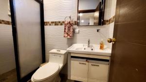 uma pequena casa de banho com WC e lavatório em Habitaciones AlojaT MIMOS diagonal al hotel oro verde em Machala