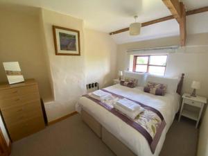A bed or beds in a room at Trysor Holiday Cottage, Coach House with sea views