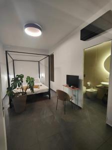 1 dormitorio con cama y escritorio con planta en Luxury B&b Euphorbia en Acireale