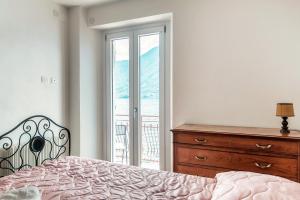 a bedroom with a bed and a dresser and a window at Da Flora Wonderful Lakefront View in Colonno