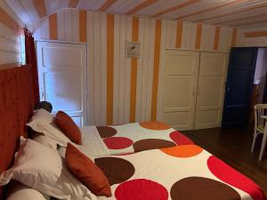 1 dormitorio con 1 cama grande y almohadas coloridas en Chambres d’hôtes chez Colombet, en Tardets-Sorholus