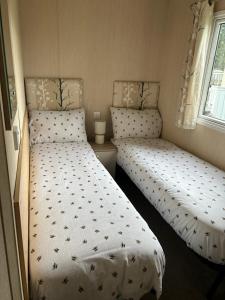 two beds in a small room at Ralph’s Retreat in Cottam