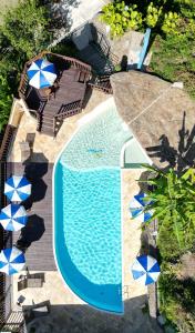 an overhead view of a swimming pool with chairs and umbrellas at Hotel Coquille in Ubatuba