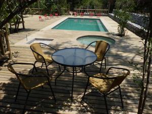 um pátio com uma mesa e cadeiras ao lado de uma piscina em Cabañas Casa en La Montaña em El Canelo