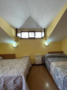 1 dormitorio con 2 camas y ventana en Duplex Luarca, en Luarca