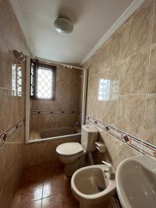 La salle de bains est pourvue de toilettes, d'un lavabo et d'une baignoire. dans l'établissement Duplex Luarca, à Luarca