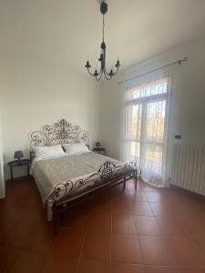 a bedroom with a bed and a window and a chandelier at Casa Rosati - Baia Flaminia in Pesaro