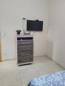 a bedroom with a dresser with a flat screen tv at Casa Temporada Nosso Recanto Piscina aquecimento Solar in Olímpia
