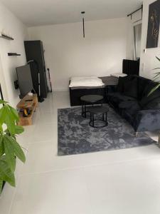 uma sala de estar com um sofá e uma mesa em Stilvolle 1-Zimmer Wohnung mit Terasse nahe Therme und Prezero Arena em Sinsheim