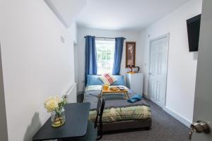 a small room with a bed and a table at Maidstone High St - Deluxe Ensuite Rooms - Fast Wi-Fi in Kent
