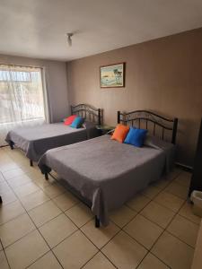 a bedroom with two beds and a window at Hotel Valle Verde in San Joaquín