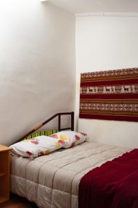a bedroom with a bed with white sheets and floral pillows at Casa Turística Las Tunas - Habitación: Apu Marcahuiri in Sicuani