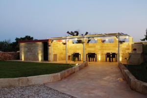 - un bâtiment avec une terrasse dotée d'une table et de chaises dans l'établissement TORRE VECCHIA RELAIS, à Ugento