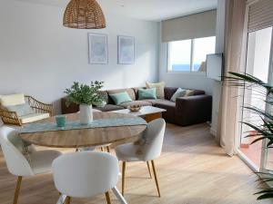 a living room with a table and a couch at Ítaca Apartment Peñiscola in Peñíscola