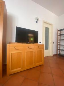 una TV su un mobile in legno in una stanza di Casa Rosati - Baia Flaminia a Pesaro