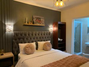 a bedroom with a large bed with a padded headboard at LuxuryAirportLodge near OR TAMBO in Kempton Park