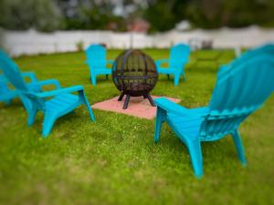 a group of blue lawn chairs sitting in the grass at Claddagh Motel & Suites in Rockport