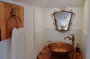 baño con lavabo de cobre y espejo en AYCA La Flora Hotel Boutique, en Valparaíso