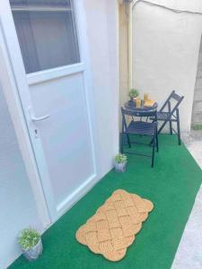 eine Terrasse mit einer Tür, einem Tisch und einem Teppich in der Unterkunft Duplex aux Porte de Paris in Bourg-la-Reine