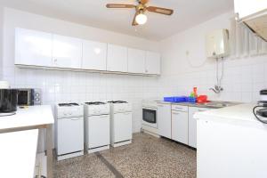 Kuchnia wyposażona jest w białe urządzenia i wentylator sufitowy. w obiekcie Double Room Tucepi 5263f w Tučepi